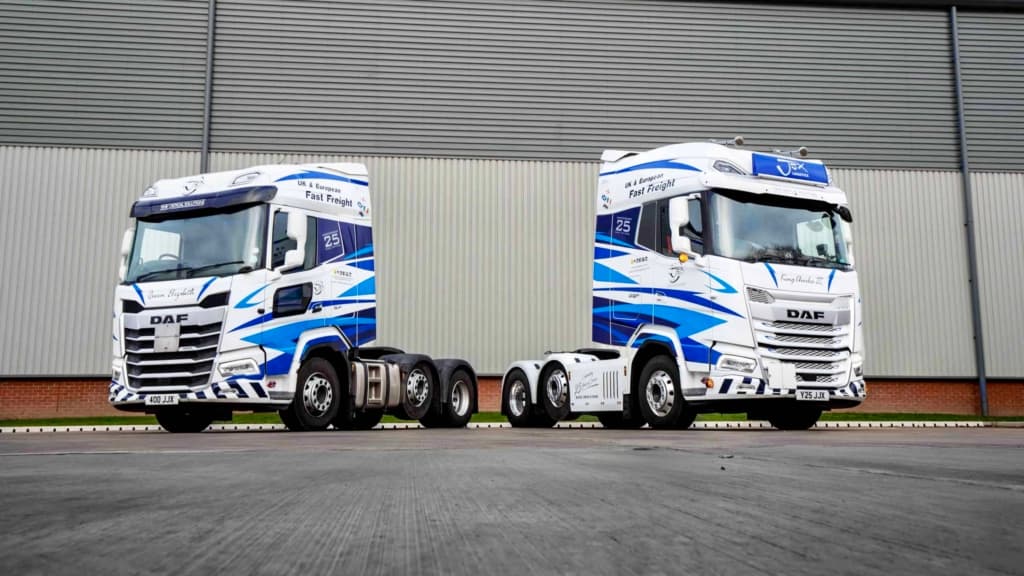 Two tractor units parked outside a commercial vehicle depot